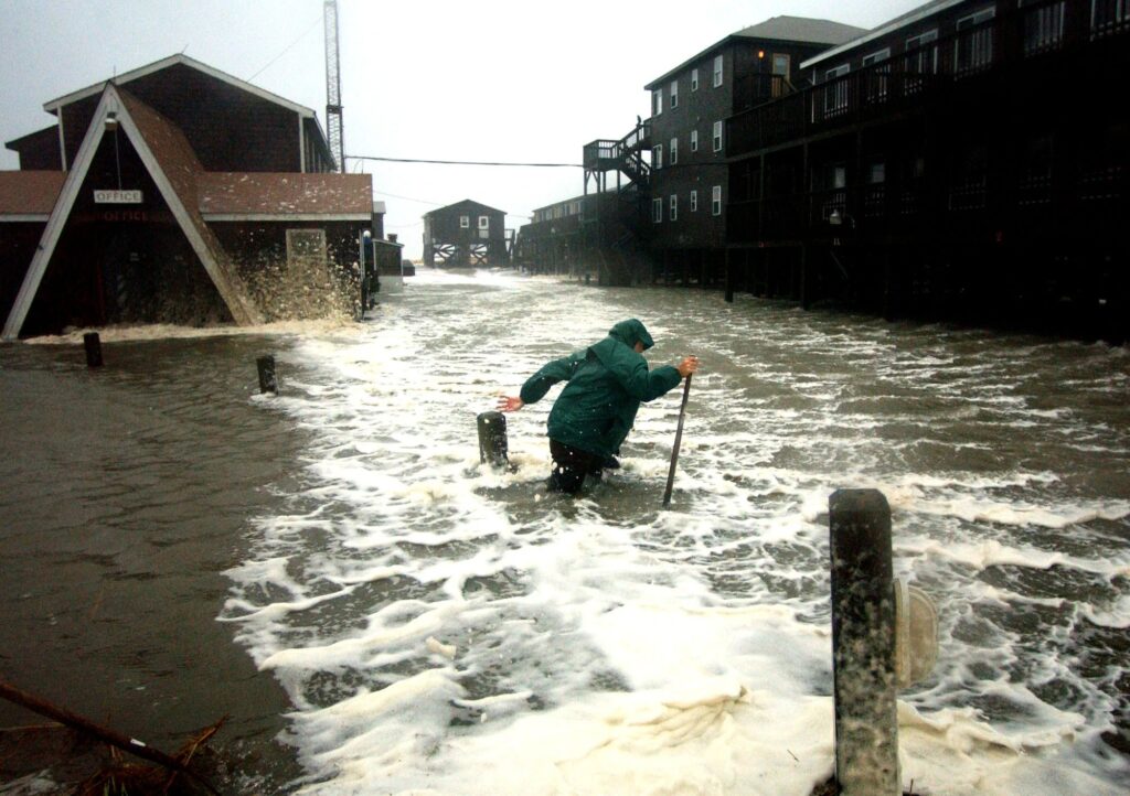 A photo of a man walking through flooding in Buxton after Hurricane Isabel